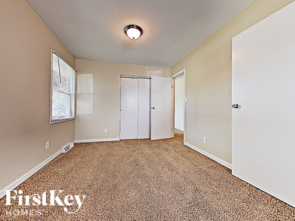 an empty living room with a closet and a window