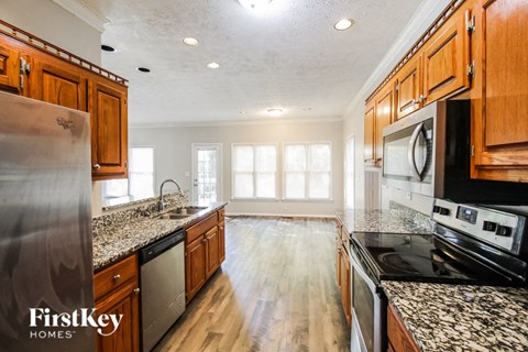 a kitchen with granite counter tops and wooden cabinets