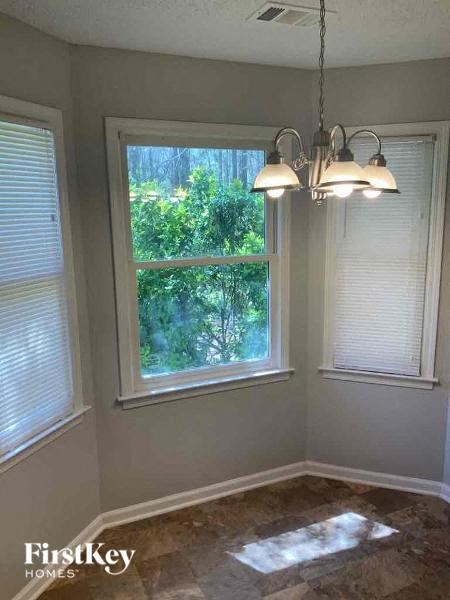A room with a window and a view of trees outside.