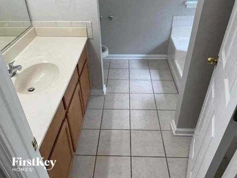 A bathroom with a sink, mirror, and toilet.