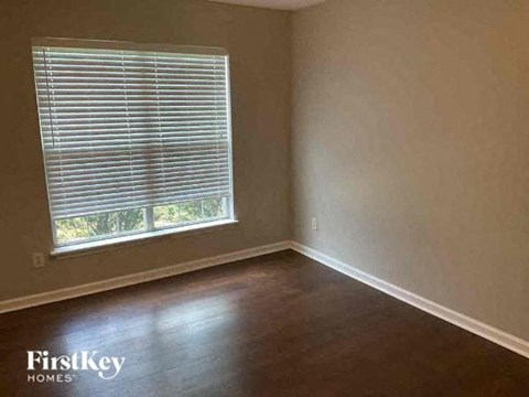 A room with a window and wooden flooring.