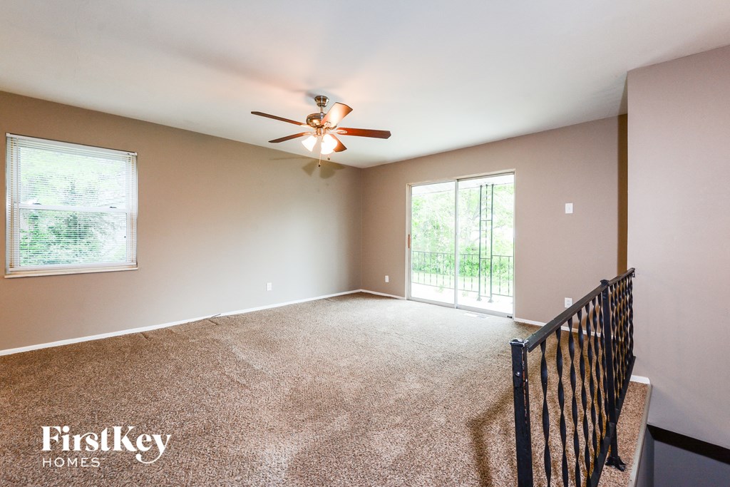 an empty living room with a ceiling fan
