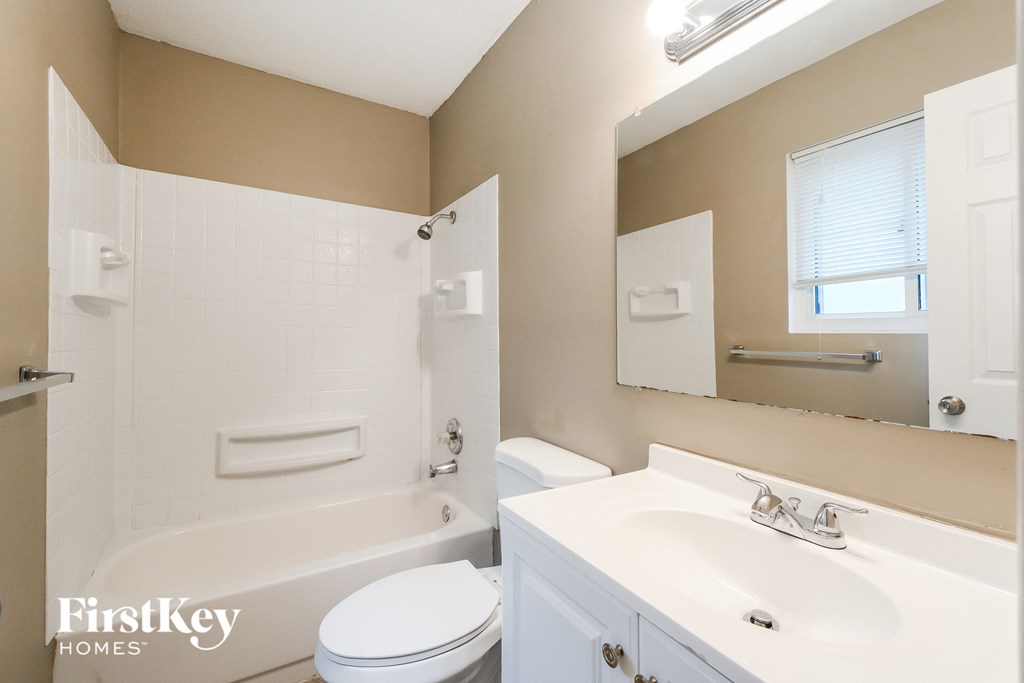 a bathroom with a sink toilet and tub and a mirror