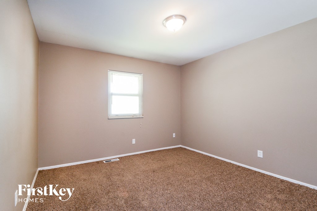 a bedroom with a carpeted floor and a window