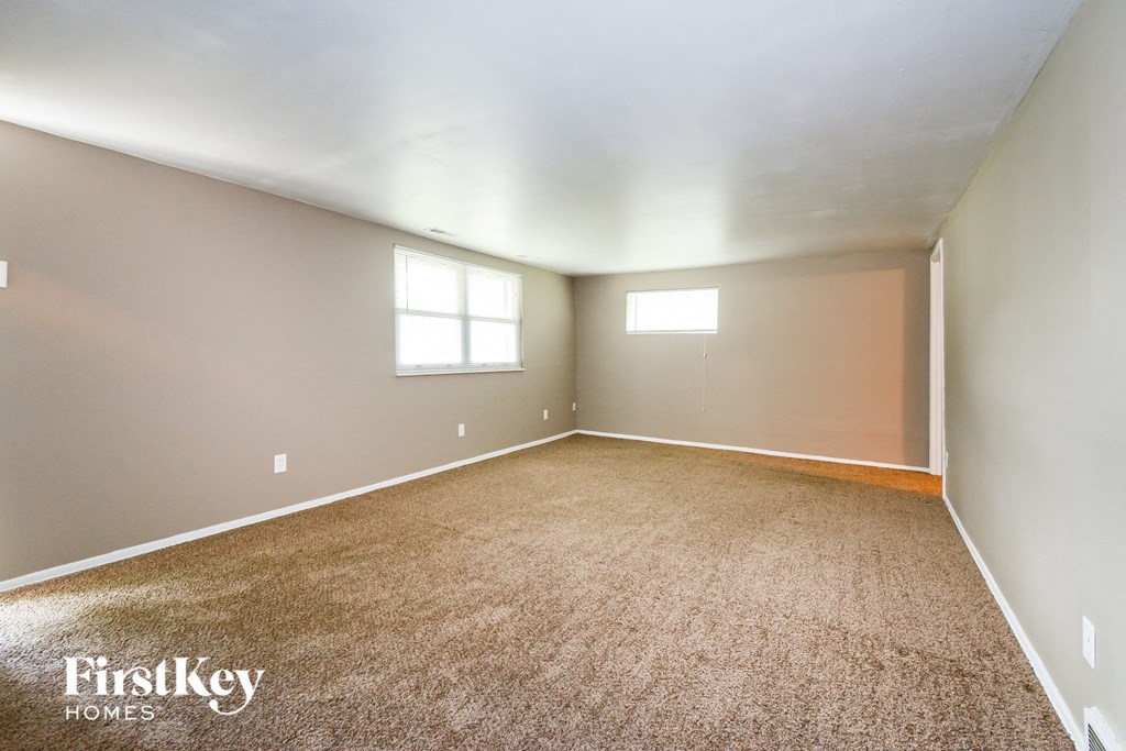 an empty room with carpet and a window