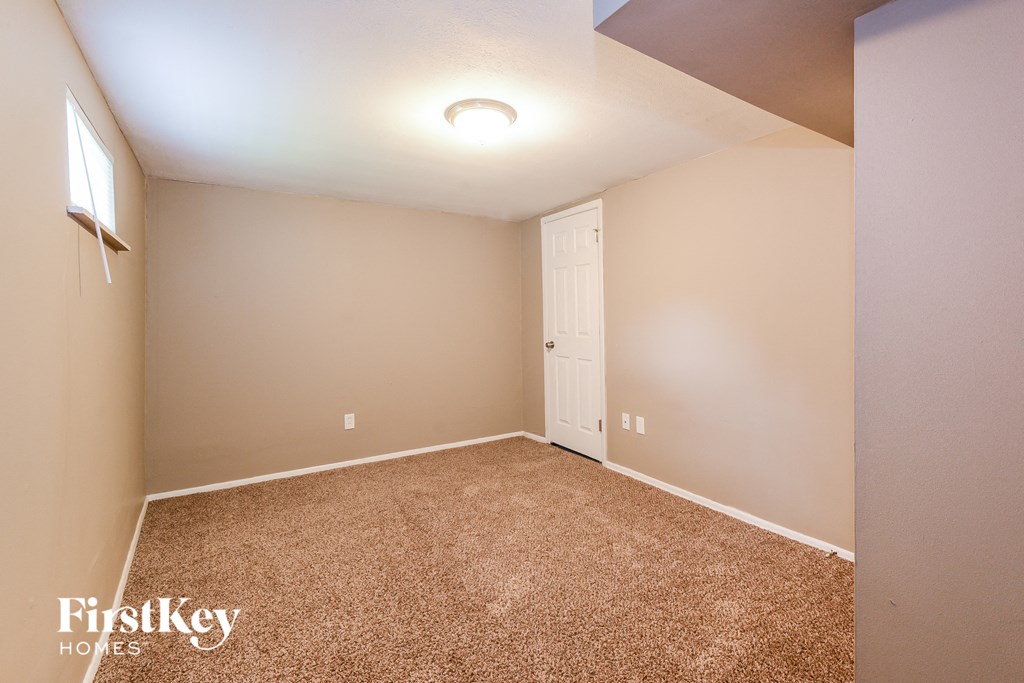 a bedroom with a carpeted floor and a white door