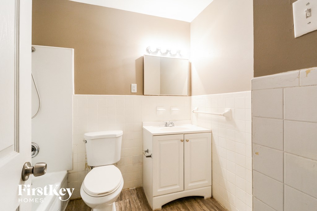 a bathroom with a toilet and a sink and a mirror