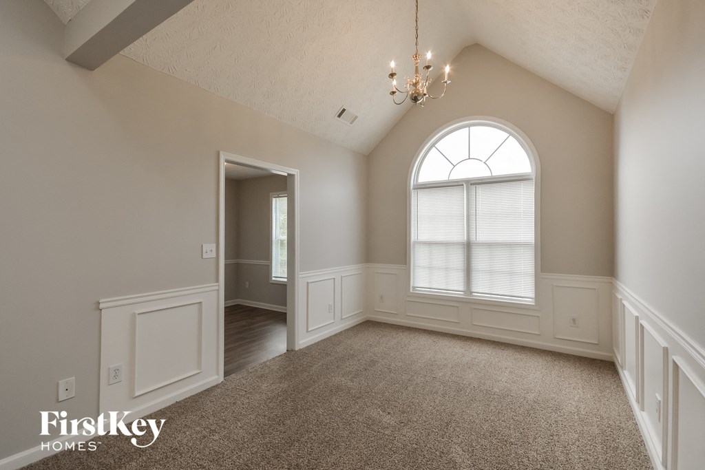 an empty living room with a large arched window