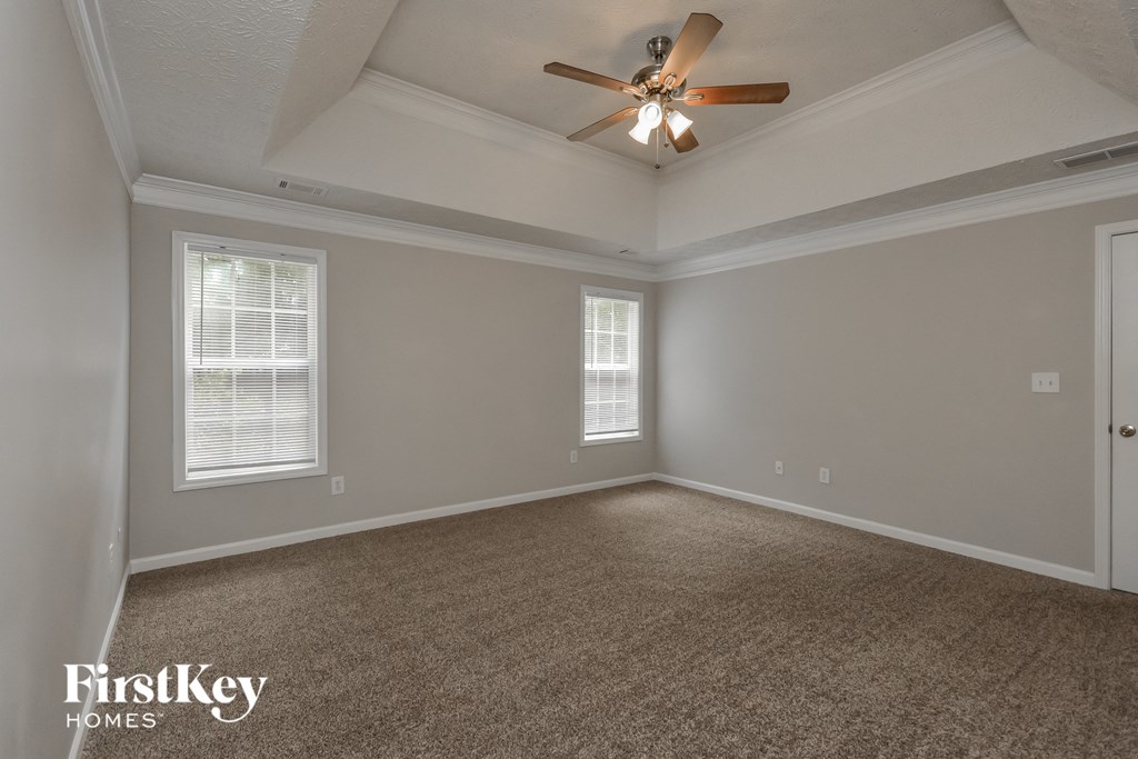 the living room of an empty house with a ceiling fan