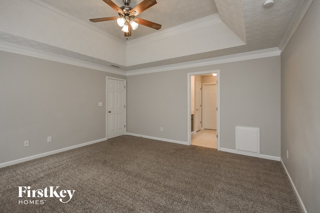 the living room of an empty house with a ceiling fan
