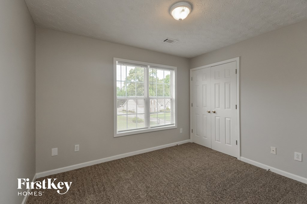 the living room of an empty house with a window and a door