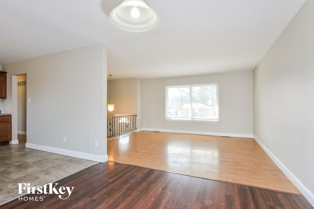 an empty living room with hardwood floors and a window