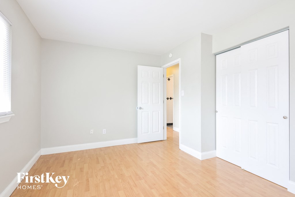 a bedroom with a hard wood floor and white doors