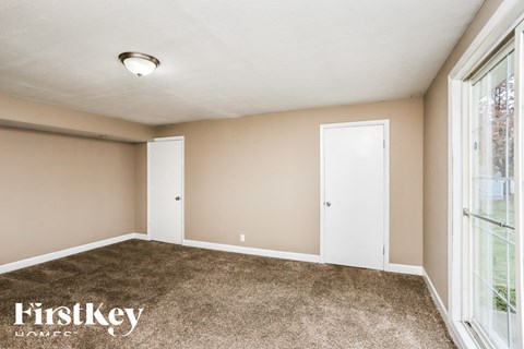 a bedroom with a carpeted floor and a large window