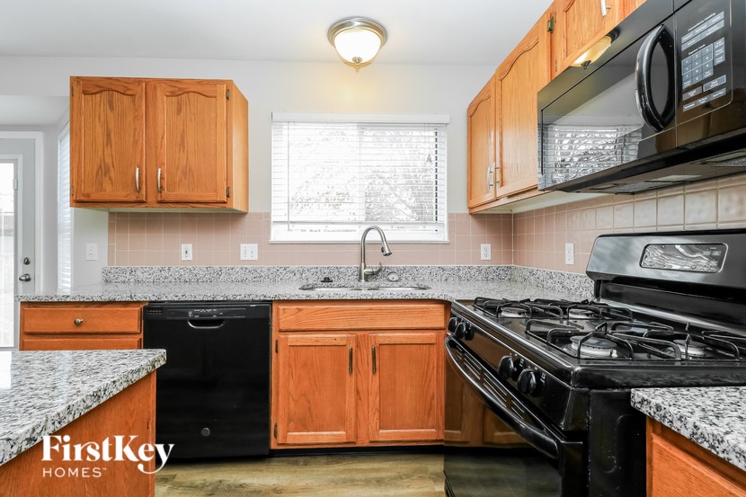 A kitchen with wooden cabinets and a black stove top oven.