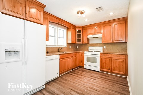 A kitchen with wooden cabinets and a white refrigerator.