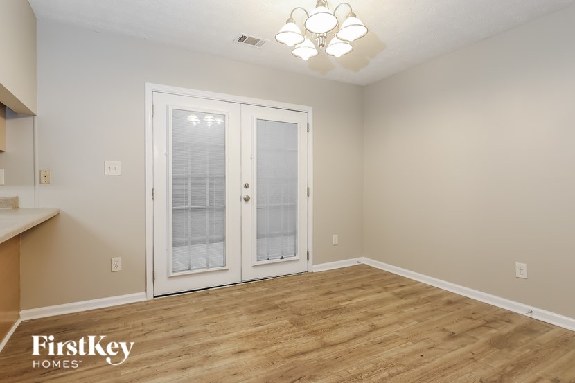 A room with a wooden floor and a white door.