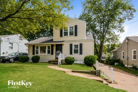 A house with a white picket fence in front of it.