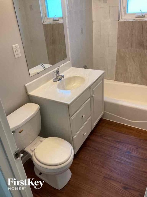 A white toilet sits next to a sink in a bathroom.