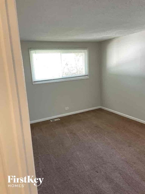 A room with a window and carpeted floor.