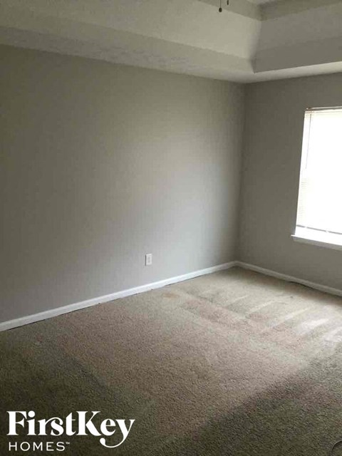 an empty room with gray walls and a window