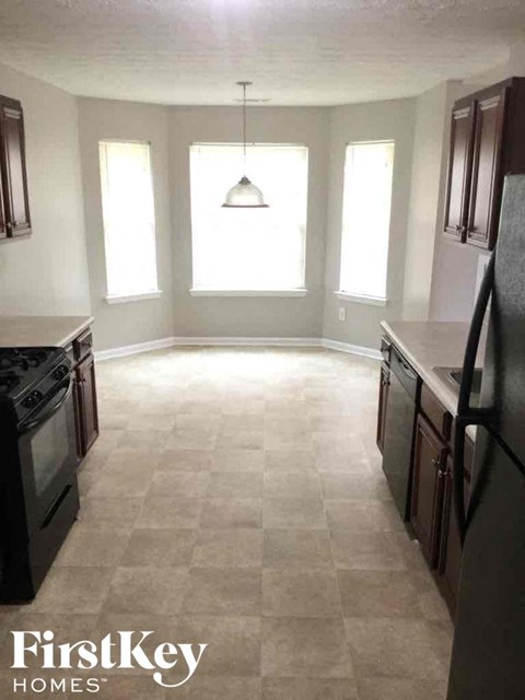 an empty kitchen in a house with a light hanging from the ceiling