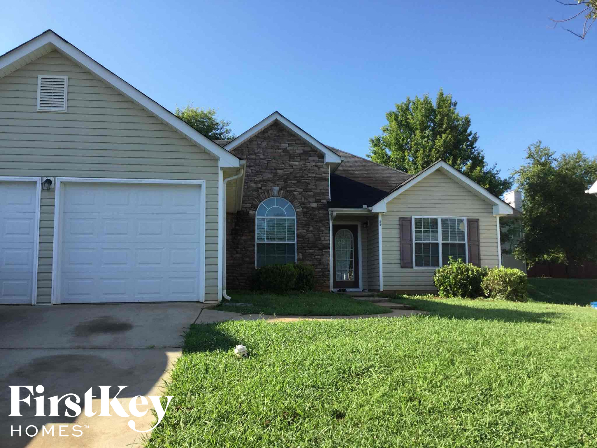 a home with a lawn and a white garage door