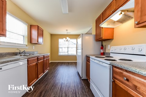 A kitchen with wooden cabinets and a white stove top oven.