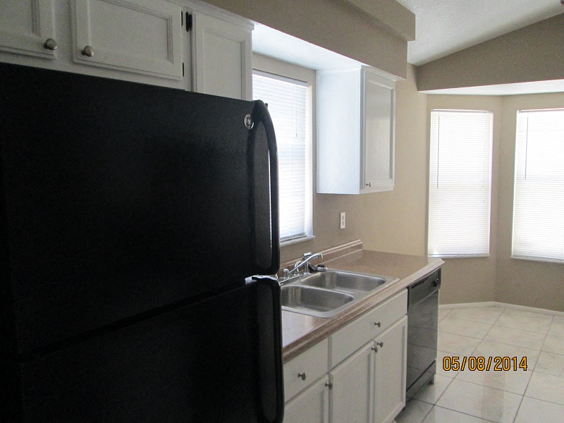 a kitchen with a black refrigerator and a sink
