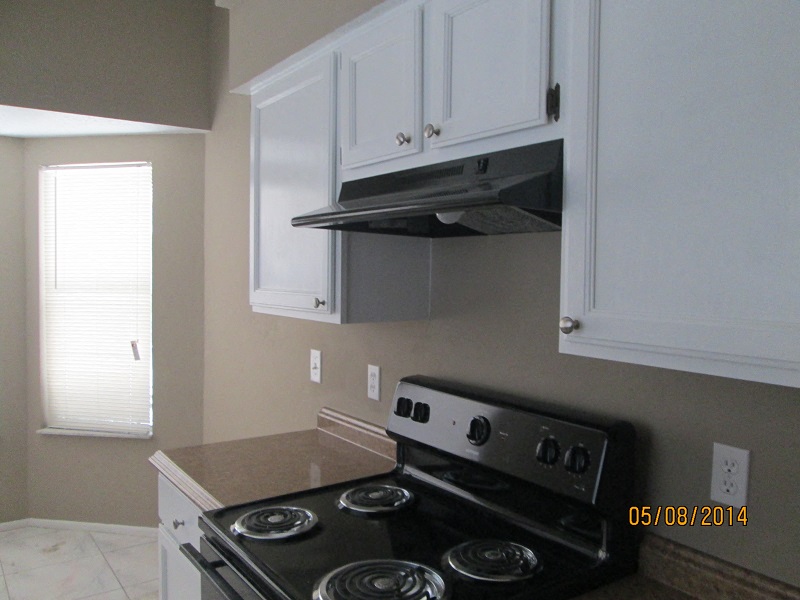 a kitchen with a stove and white cabinets