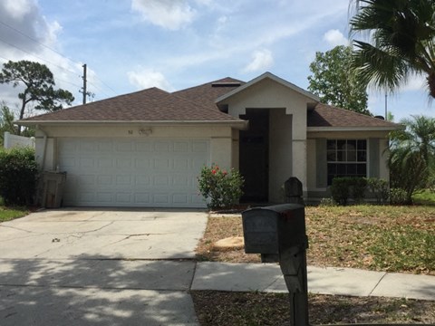 a house with a driveway and a parking meter in front of it