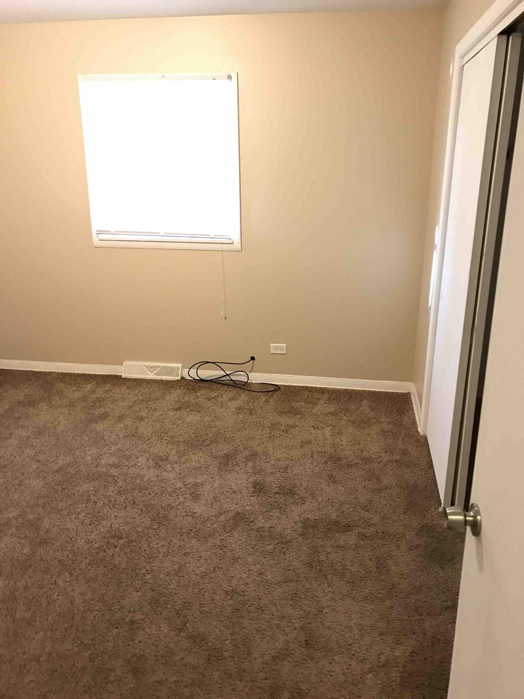 a room with a carpeted floor and a window