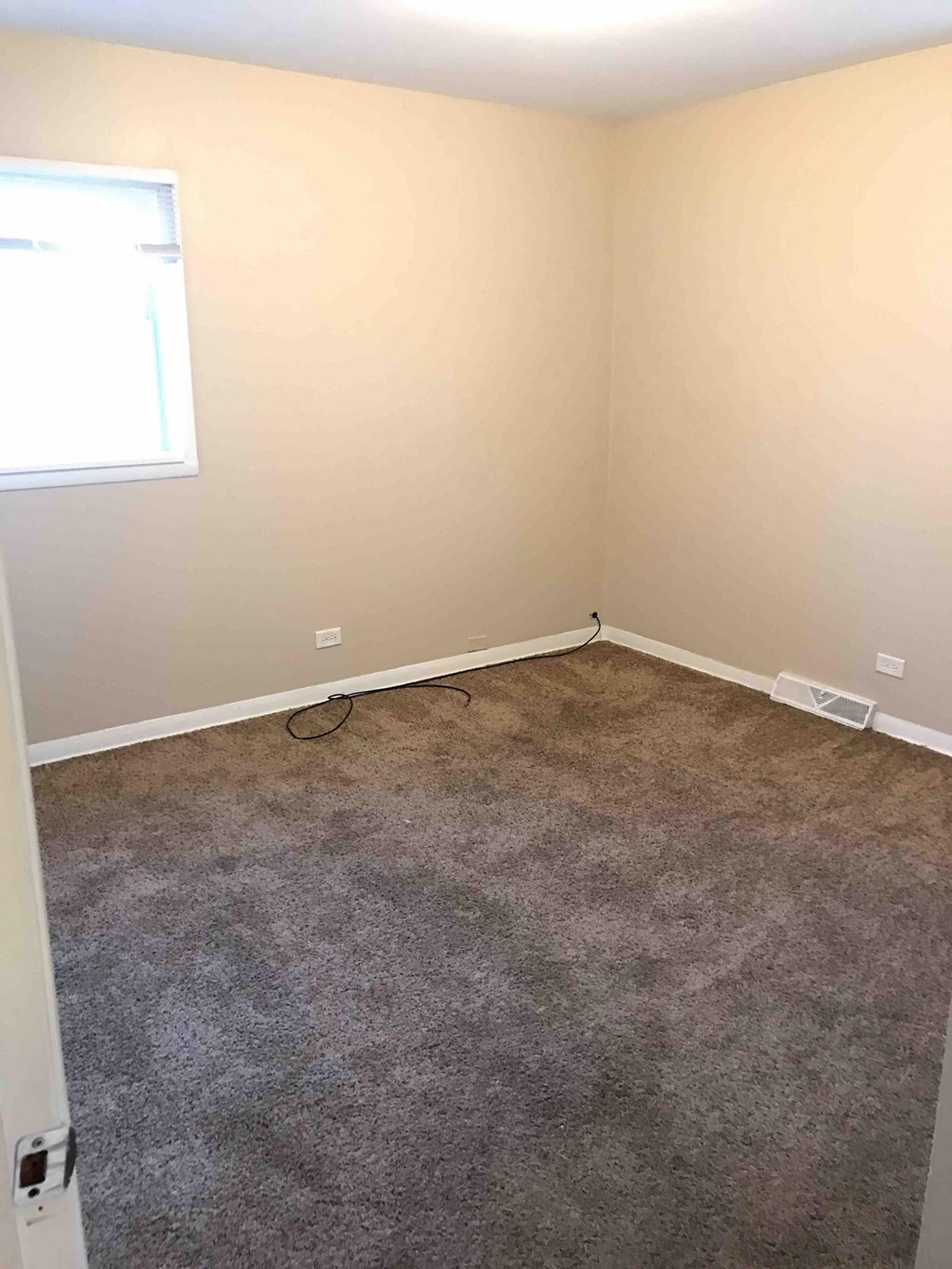 a room with a carpeted floor and a window