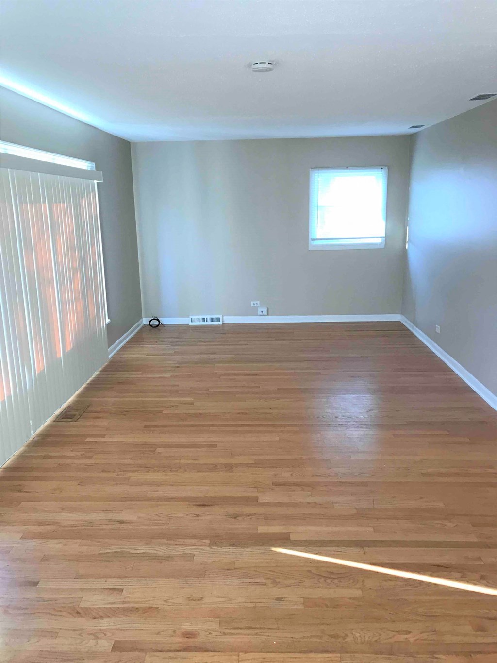 an empty room with wood floors and a window