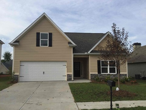 a tan house with a white garage door