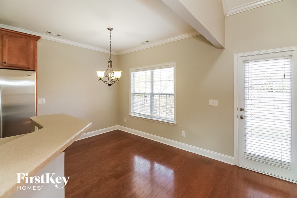 A well-lit room with wooden floors and a chandelier.
