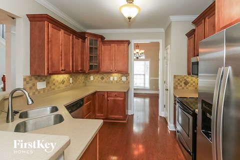 A kitchen with wooden cabinets and a stainless steel refrigerator.