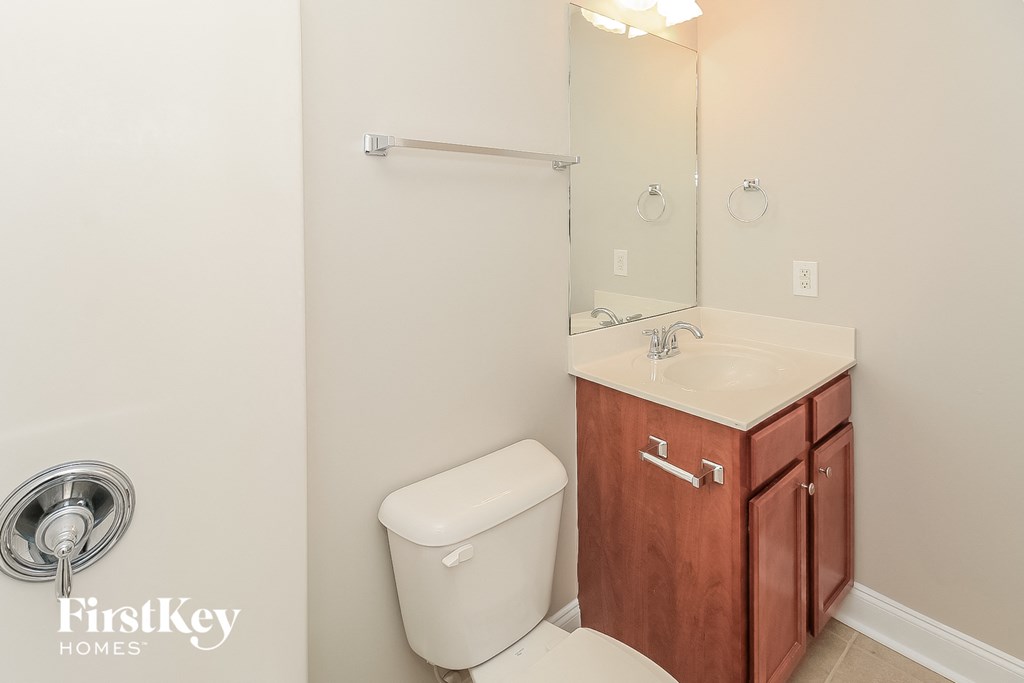 A white toilet sits next to a sink in a bathroom.