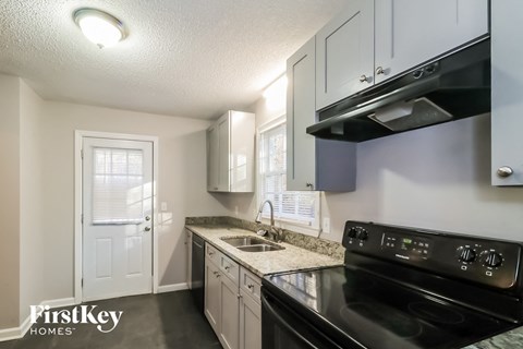 a kitchen with black appliances and white cabinets