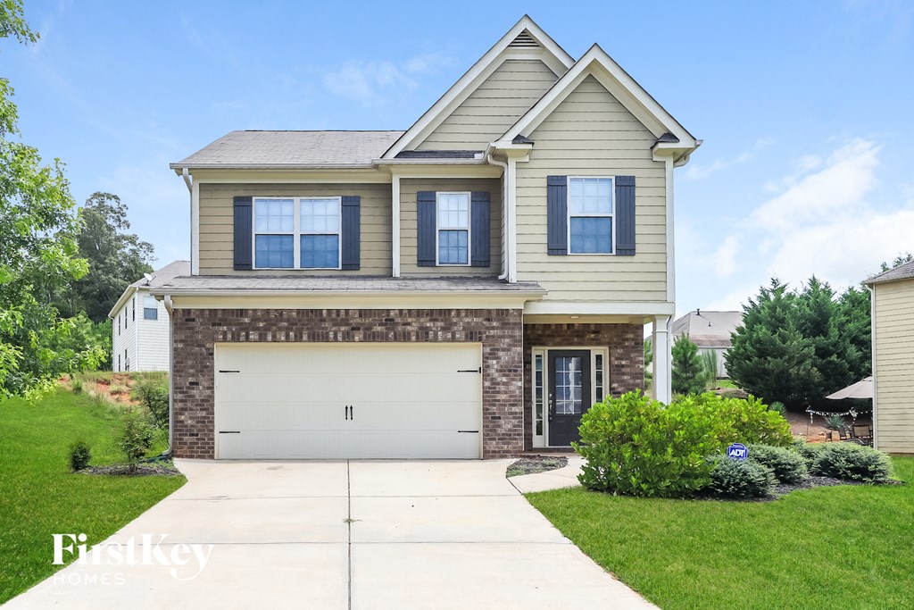 a tan and brown house with a white garage door