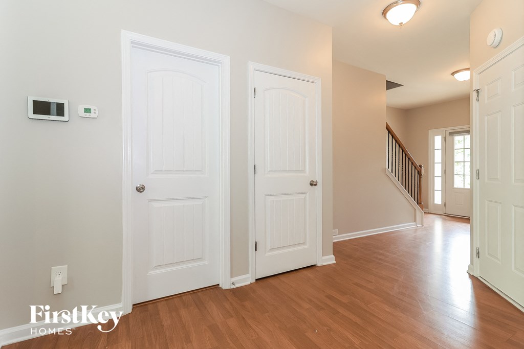 an empty living room with two white doors and a staircase