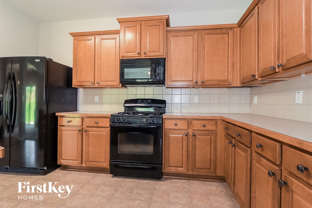 a kitchen with wooden cabinets and black appliances