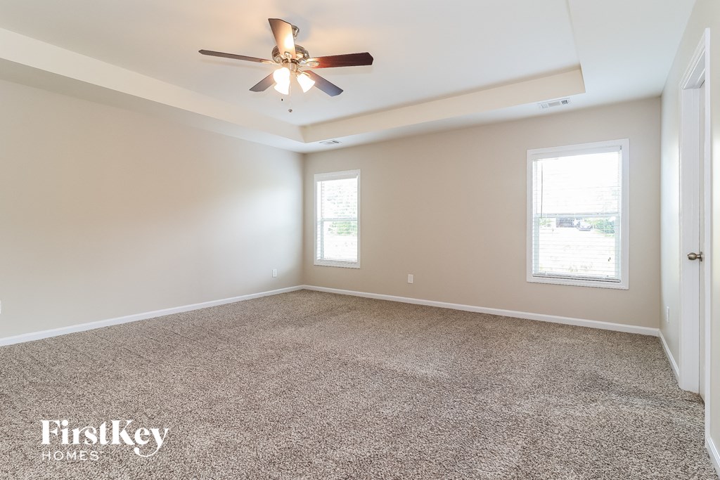a room with carpet and a ceiling fan