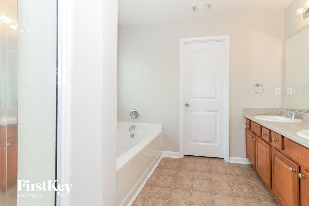 a bathroom with a tub and a sink and a mirror