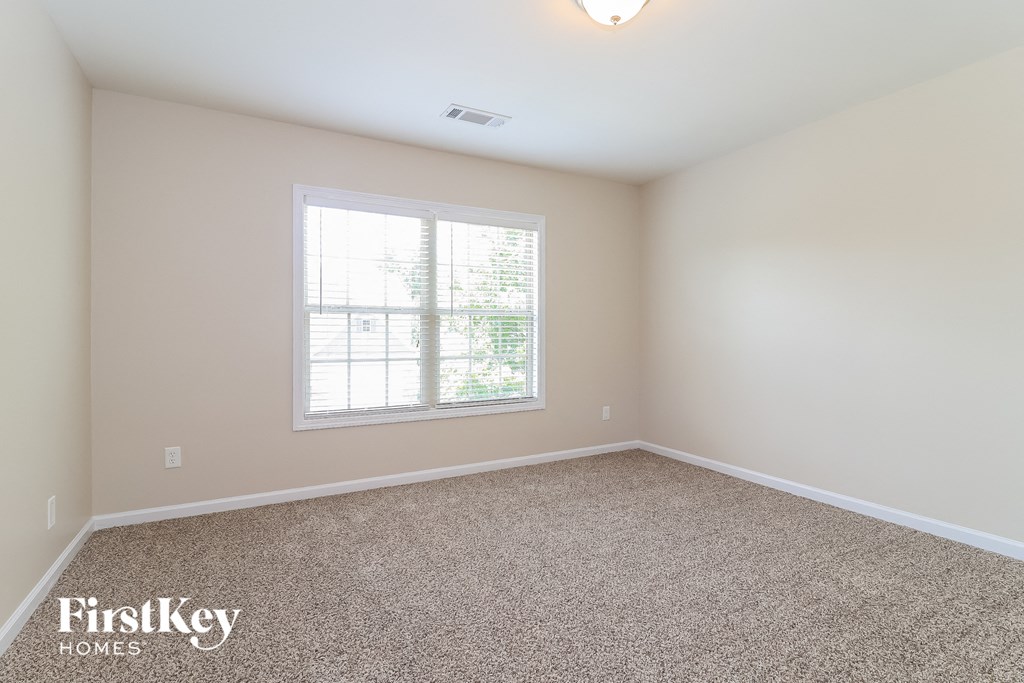 an empty room with carpet and a window