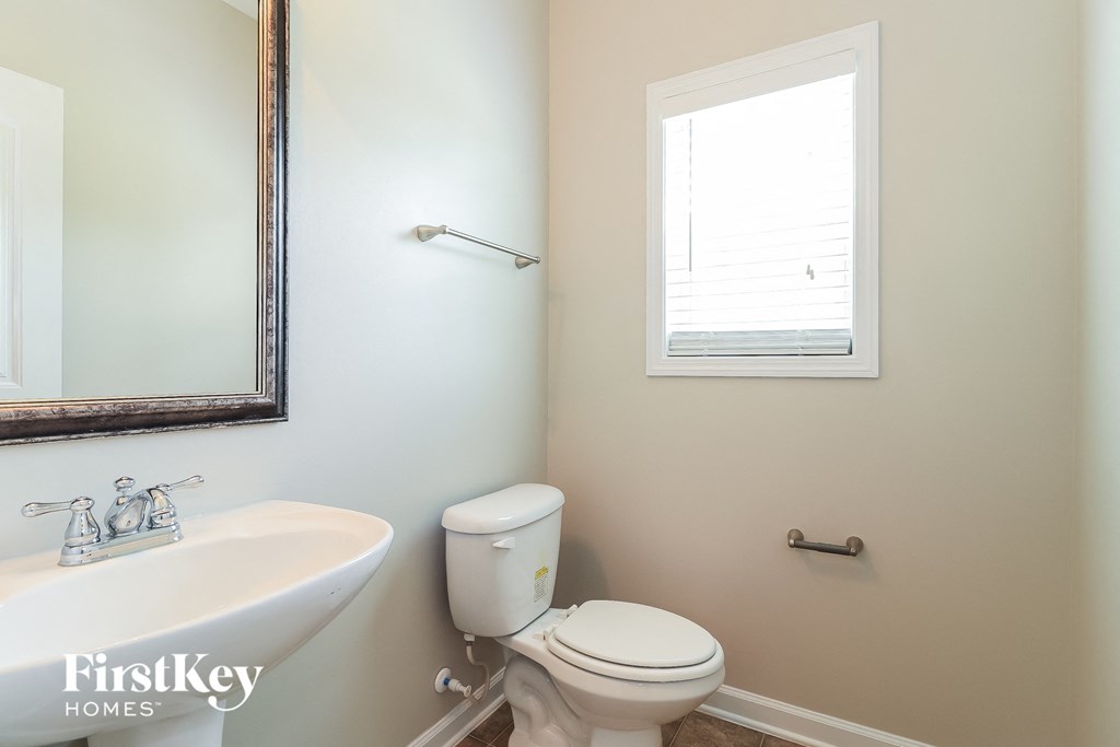 a bathroom with a toilet and a sink and a window