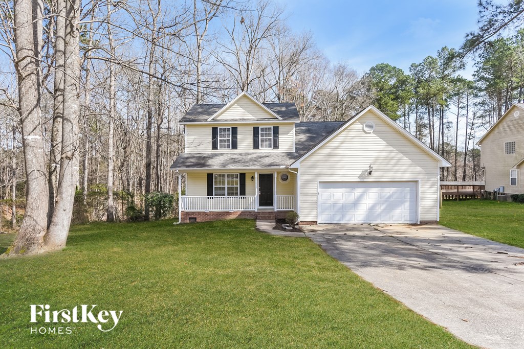 a white house with a white garage door and a lawn