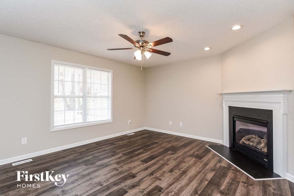 a living room with a fireplace and a ceiling fan