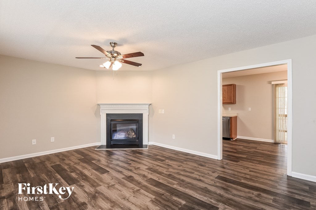 a living room with a fireplace and a ceiling fan
