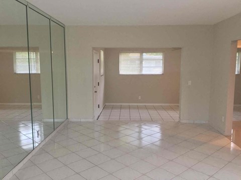 A room with a glass door and a tiled floor.